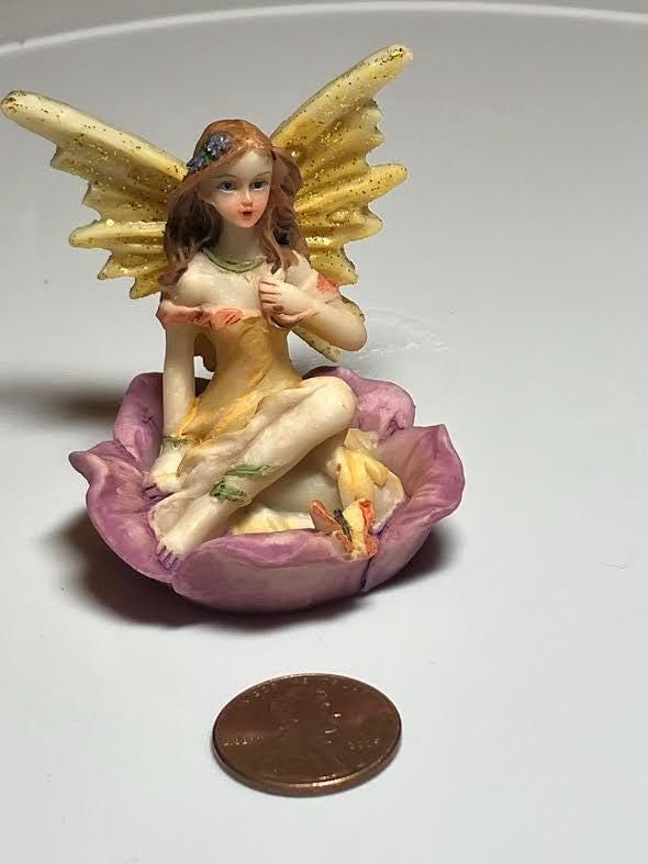 Miniature Yellow Wing Fairy Sitting on a Purple Flower